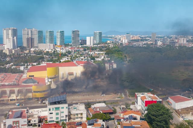 Fotografía aérea donde se ven columnas de humo tras reacciones violentas por el abatimiento de Nemesio Rubén Oseguera Cervantes, alias El Mencho, líder del Cártel Jalisco Nueva Generación (CJNG) este domingo, en Puerto Vallarta (EFE/ STR)