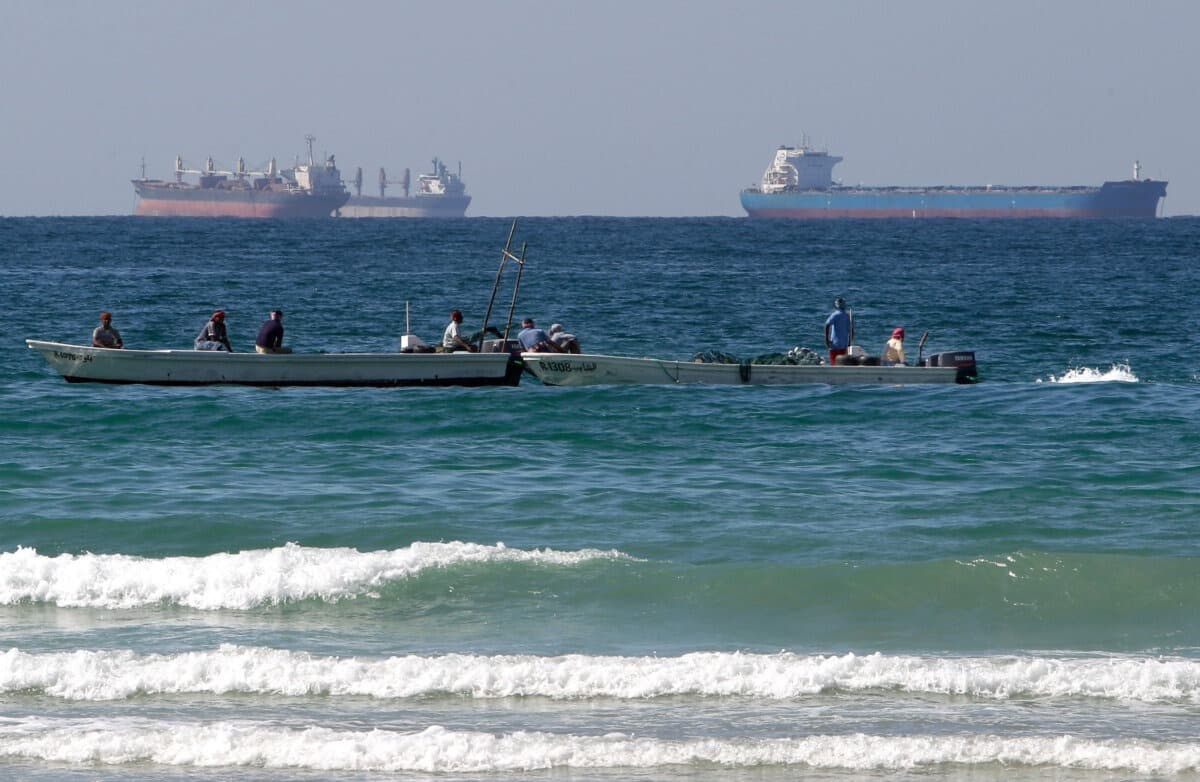Pescadores trabajando frente a petroleros al sur del estrecho de Ormuz, frente a la costa de la ciudad de Ras Al Khaimah, en los Emiratos Árabes Unidos, el 19 de enero de 2012. (Kamran Jebreili/AP Photo).