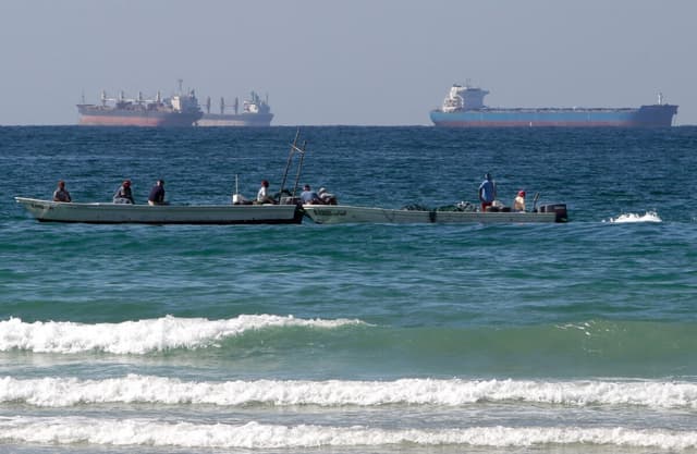 Pescadores trabajando frente a petroleros al sur del estrecho de Ormuz, frente a la costa de la ciudad de Ras Al Khaimah, en los Emiratos Árabes Unidos, el 19 de enero de 2012. (Kamran Jebreili/AP Photo).