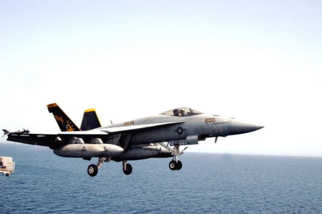 Un F/A 18E Super Hornet asignado al Escuadrón de Cazas de Ataque Uno Uno Cinco (VFA-115) "Eagles" despeja la cubierta de vuelo durante operaciones de vuelo de combate a bordo del USS Abraham Lincoln el 25 de marzo de 2003 en el Golfo Arábigo. El portaaviones se despliega para apoyar la guerra en Irak. (Philip A. McDaniel/Marina de los Estados Unidos/Getty Images).