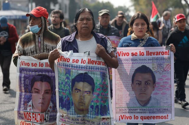 Personas caminan sosteniendo carteles con fotografías durante una peregrinación en Ciudad de México. Imagen de archivo. (EFE/ Sáshenka Gutiérrez)