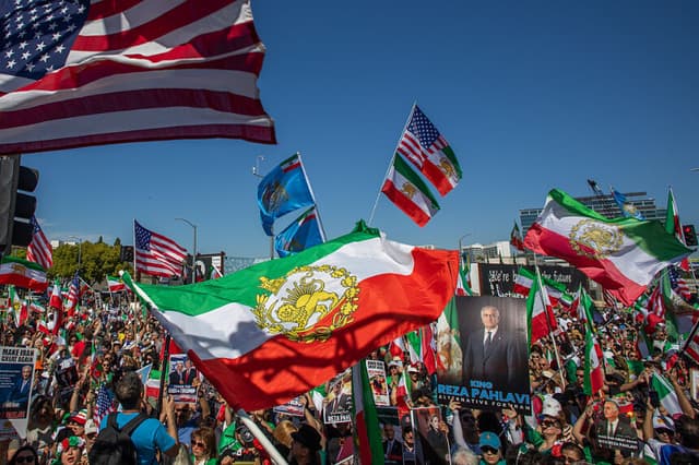 La gente ondea banderas iraníes anteriores a la Revolución Islámica de 1979 y banderas estadounidenses mientras miembros de la comunidad iraní celebran frente al Edificio Federal el 1 de marzo de 2026 en Los Ángeles, California. (Apu Gomes/Getty Images)