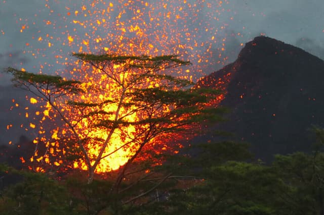 Una fuente de lava brota de una fisura del volcán Kilauea, formando un nuevo cono, en la isla grande de Hawái, el 20 de mayo de 2018, en Kapoho, Hawái. (Mario Tama/Getty Images)