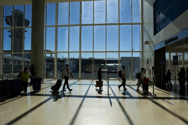 Pasajeros y tripulación se dirigen a un control de seguridad de la Administración de Seguridad en el Transporte (TSA) mientras viajan por el Aeropuerto Internacional de Los Ángeles (LAX) en Los Ángeles, el 26 de noviembre de 2025. (Foto de Patrick T. Fallon / AFP a través de Getty Images).