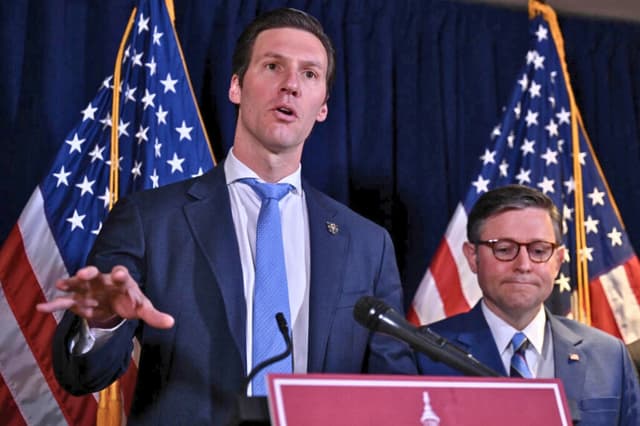 El representante estadounidense Pat Harrigan (R-N.C.) habla mientras el presidente de la Cámara de Representantes, Mike Johnson (R-La.), observa durante una rueda de prensa tras una reunión a puerta cerrada con los republicanos de la Cámara, en la oficina del Comité Nacional Republicano en el Capitolio, en Washington, el 25 de marzo de 2025. (Drew Angerer/AFP a través de Getty Images).