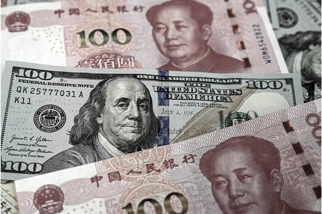 Billetes chinos de 100 yuanes y billetes estadounidenses de 100 dólares, en Beijing el 8 de abril de 2025. (Jade Gao/AFP vía Getty )