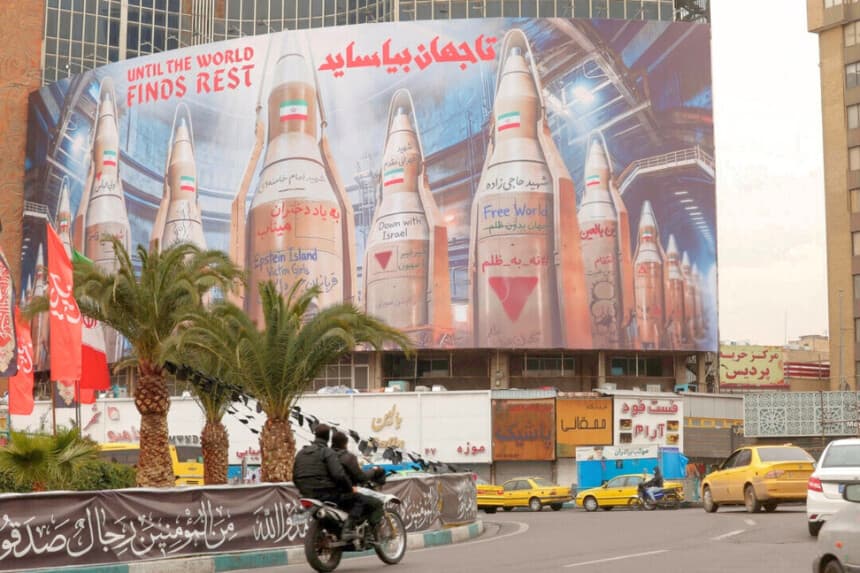 Unos motociclistas pasan junto a una gran valla publicitaria con imágenes de misiles iraníes, en medio del conflicto entre Estados Unidos e Israel con Irán, en Teherán, Irán, el 15 de marzo de 2026. (Alaa Al-Marjani/Reuters).