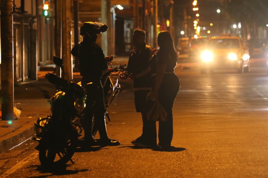 Un integrante de la Policía de Ecuador conversa con ciudadanos tras el toque de queda este domingo, en Guayaquil, Ecuador. (EFE/ Jonathan Miranda Vanegas)