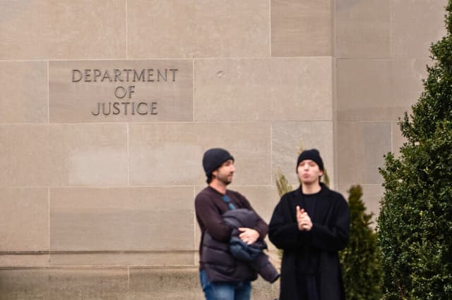 Varias personas se encuentran frente al edificio del Departamento de Justicia en Washington el 6 de enero de 2026. (Madalina Kilroy/The Epoch Times).