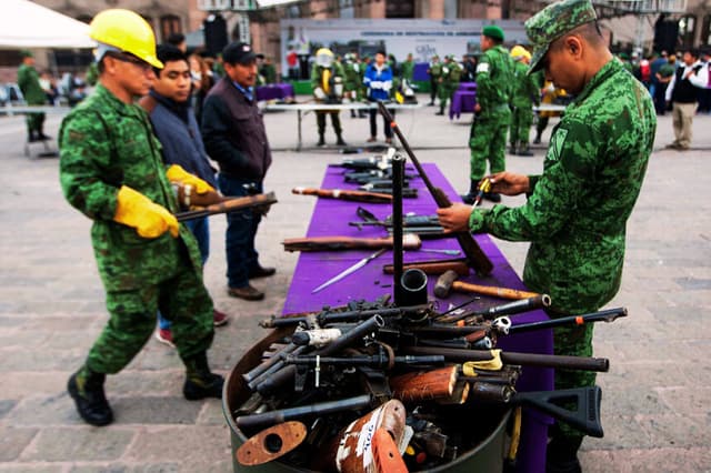 Soldados destruyen armas utilizadas en delitos graves y confiscadas por el Ejército mexicano a narcotraficantes en los estados de Tamaulipas y San Luis Potosí, en Monterrey, México, el 17 de enero de 2017. (JULIO CESAR AGUILAR/AFP vía Getty Images)