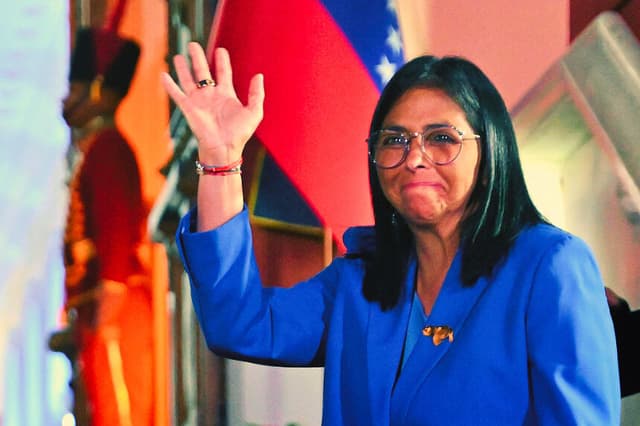 La presidenta interina de Venezuela, Delcy Rodríguez, saluda con la mano tras firmar la ley de amnistía aprobada por la Asamblea Nacional en el Palacio de Miraflores, en Caracas, el 19 de febrero de 2026. (Juan BARRETO / AFP vía Getty Images)