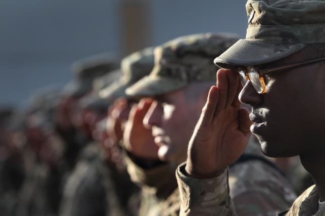 Imagen ilustrativa: Soldados del Ejército de EE. UU. saludan durante el himno nacional. (John Moore/Getty Images)
