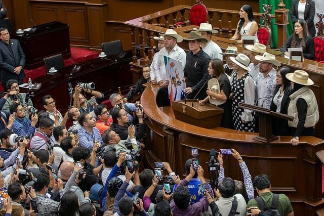 La viuda del difunto alcalde Carlos Manzo, Grecia Quiroz, acompañada por el diputado estatal Carlos Tafolla y funcionarios de la ciudad de Uruapan, pronunció un discurso en el Congreso del Estado de Michoacán tras jurar como alcaldesa de Uruapan en Morelia, estado de Michoacán, México, el 5 de noviembre de 2025. El gobierno mexicano informó el 2 de noviembre que el alcalde de Uruapan, Carlos Manzo, quien fue asesinado la noche anterior durante un acto público en el estado occidental de Michoacán, se encontraba bajo protección oficial desde diciembre del año pasado. (Foto de ENRIQUE CASTRO/AFP vía Getty Images)