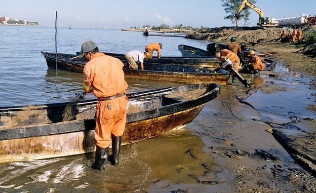 Trabajadores petroleros y pescadores contratados por la paraestatal Petroleos Mexicanos limpianen una zona de un derrame de crudo. Imagen de archivo. (EFE/David Hernandez)