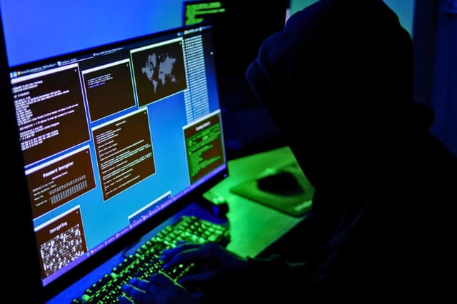 En esta ilustración fotográfica, un hacker teclea en el teclado de un ordenador el 13 de mayo de 2025. (Oleksii Pydsosonnii/The Epoch Times).