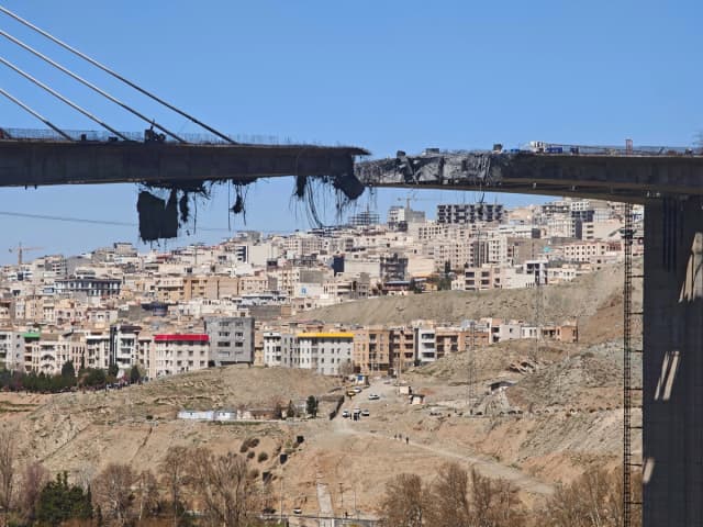 Hormigón y barras de refuerzo cuelgan de un puente B1 dañado, un día después de haber sido destruido por un ataque aéreo, al oeste de Teherán, en Karaj, Irán, el 3 de abril de 2026. (Majid Saeedi/Getty Images).