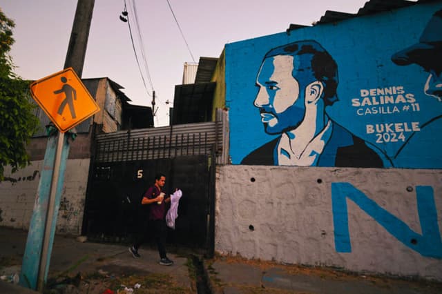 Un hombre pasa junto a un mural que representa al presidente de El Salvador y candidato a la reelección por el partido Nuevas Ideas, Nayib Bukele, en Mejicanos, San Salvador, el 2 de febrero de 2024. (MARVIN RECINOS/AFP vía Getty Images)