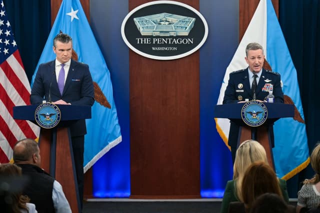 El secretario de Guerra, Pete Hegseth (izquierda), observa mientras el presidente del Estado Mayor Conjunto, general Dan Caine, habla durante una rueda de prensa en el Pentágono, en Washington, el 31 de marzo de 2026. (Oliver Contreras/AFP vía Getty Images)