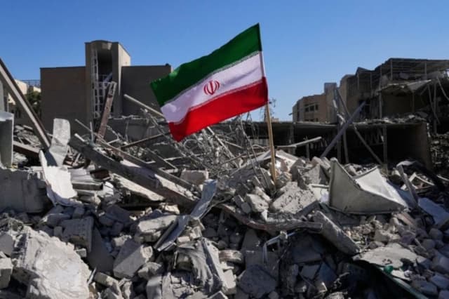 Una bandera iraní se encuentra entre las ruinas de una comisaría de policía alcanzada durante la campaña militar estadounidense-israelí en Teherán, Irán, el 3 de marzo de 2026. (Foto AP/Vahid Salemi)
