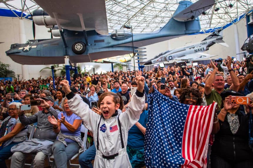 Una multitud observa la retransmisión en directo del regreso a la Tierra de los tripulantes de la misión Artemis II en el Museo del Aire y el Espacio de San Diego, durante una fiesta organizada para seguir el amerizaje de la tripulación en el océano Pacífico, celebrada en San Diego el 10 de abril de 2026. (Apu Gomes/AFP vía Getty Images).