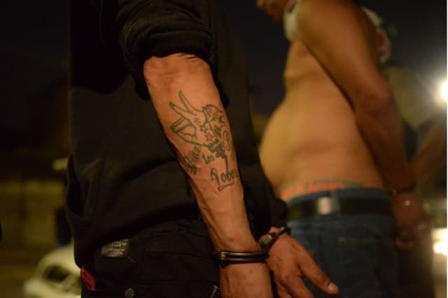 Hombre con tatuaje relacionado con la banda criminal "Los Lobos" es detenido durante una operación en la que se detuvo a tres personas en Guayaquil, Ecuador, el 27 de enero de 2024. (GERARDO MENOSCAL/AFP vía Getty Images)