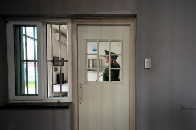 Un guardia paramilitar permanece de pie junto a una puerta de seguridad en el interior del Centro de Detención n.º 1 durante una visita guiada organizada por el Gobierno en Beijing el 25 de octubre de 2012. (Ed Jones/AFP vía Getty Images).