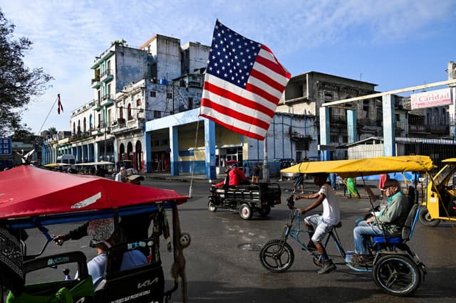 Un triciclo que se utiliza como taxi está decorado con la bandera estadounidense en La Habana, el 21 de enero de 2025. (YAMIL LAGE/AFP vía Getty Images)