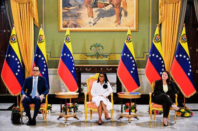 La presidenta interina de Venezuela, Delcy Rodríguez (C), observa junto al vicepresidente sectorial de Economía y Finanzas, Calixto Ortega (I), y la ministra de Petróleo e Hidrocarburos, Paula Henao, durante una rueda de prensa tras la ceremonia de firma de un acuerdo entre Chevron Venezuela y el Gobierno nacional en el Palacio de Miraflores, en Caracas, el 13 de abril de 2026. (Juan BARRETO / AFP vía Getty Images)