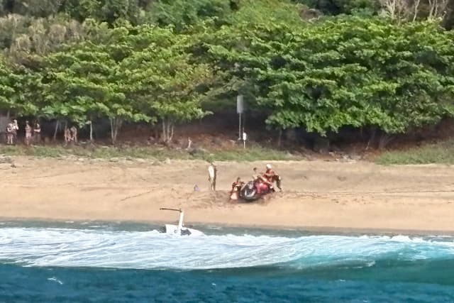 Miembros de Kauai Ocean Safety y otras personas prestan asistencia a los afectados tras el accidente de un helicóptero turístico de Airborne Aviation en la playa de Kalalau, en Kauai (Hawái), el 26 de marzo de 2026. (Contramaestre de segunda clase Tyler Robertson/Estación de Kauai/Guardia Costera de EE. UU. vía AP)