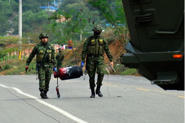 Soldados colombianos transportan una bombona de gas que, según se afirma, fue cargada con explosivos por el ELN, tras desactivarla en una carretera cerca de Cúcuta, en el departamento de Norte de Santander, Colombia, el 15 de diciembre de 2025. (SCHNEYDER MENDOZA / AFP vía Getty Images)