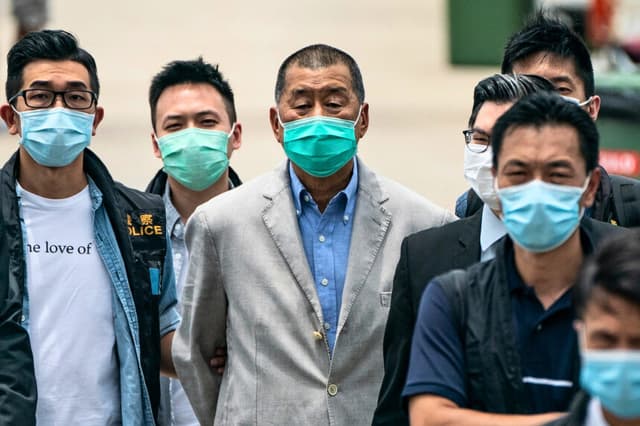 El magnate de los medios de comunicación de Hong Kong, Jimmy Lai, es escoltado por la policía hasta la sede del Royal Hong Kong Yacht Club Shelter Cove para la recogida de pruebas, en el marco de las investigaciones en curso en Hong Kong, el 11 de agosto de 2020. (Anthony Kwan/Getty Images).