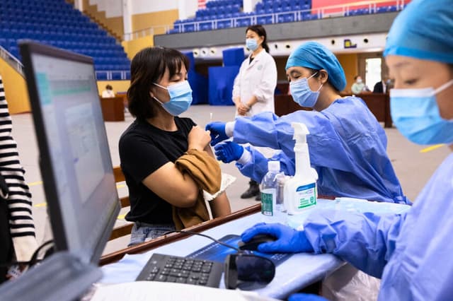 Un residente recibe la vacuna contra COVID-19 en Wuhan, en la provincia central de Hubei, China, el 14 de octubre de 2021. (STR/AFP vía Getty Images).