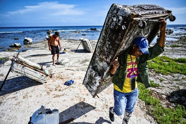 Un pescador cubano transporta su balsa improvisada tras faenar en la bahía de La Habana el 22 de julio de 2024. Cuando el tiempo lo permite, los pescadores artesanales se hacen a la mar en balsas improvisadas de poliestireno para suplir la falta de medios y combustible. (YAMIL LAGE/AFP vía Getty Images)