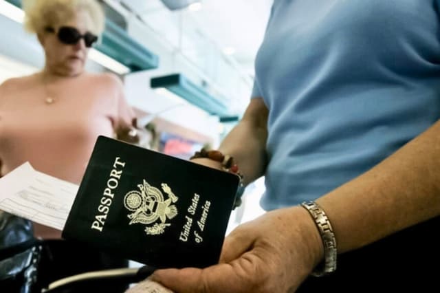 Un viajero saca su pasaporte antes de facturar en el Aeropuerto Internacional de San Diego, en California, el 8 de enero de 2006. (Sandy Huffaker/Getty Images).