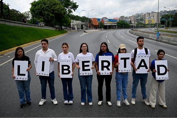 Estudiantes y familiares de presos políticos sostienen pancartas cuyas letras forman la palabra "Libertad" en español, mientras participan en una protesta para exigir su liberación frente a la Universidad Central de Venezuela (UCV) en Caracas, el 13 de mayo de 2026. (Federico PARRA / AFP vía Getty Images)