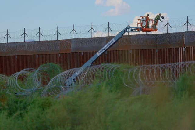Ingenieros de combate del Ejército de Estados Unidos colocan alambre de púas en el muro fronterizo entre Estados Unidos y México para reforzar la seguridad en El Paso, Texas, visto desde Ciudad Juárez (México), el 24 de julio de 2025. (José Luis González/Reuters).
