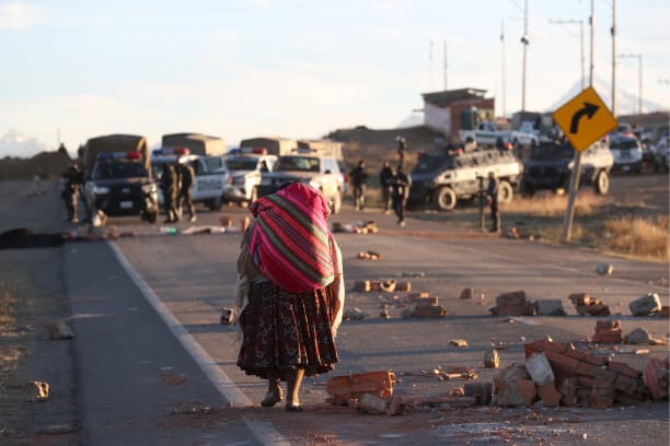 Una persona camina por una carretera bloqueada con escombros este sábado 16 de mayo en Achica Arriba, Bolivia. (EFE/ Luis Gandarillas)