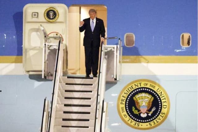 El presidente estadounidense Donald Trump saluda a la multitud en la puerta del Air Force One a su llegada al Aeropuerto Internacional de Beijing, el 13 de mayo de 2026. (Alex Wong/Getty Images)