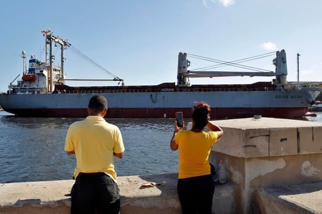 Personas toman fotografías de la llega de un barco con ayuda humanitaria este lunes, a La Habana, Cuba. (EFE/ STR)