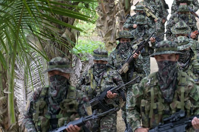 Miembros del grupo disidente Segunda Marquetalia, perteneciente a las FARC, marchan en una finca de Llorente, zona rural de la ciudad portuaria de Tumaco, departamento de Nariño, Colombia, el 31 de agosto de 2024. Menos de tres meses después de haber iniciado conversaciones de paz con el gobierno, uno de los grupos rebeldes de izquierda más grandes de Colombia dijo que las negociaciones están "bloqueadas" y acusa al gobierno del presidente Gustavo Petro de no cumplir con sus principales demandas. (Foto de JOAQUIN SARMIENTO/AFP vía Getty Images)