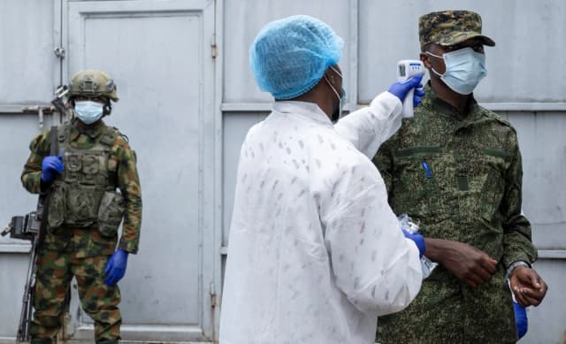 Un trabajador sanitario toma la temperatura de un miembro del M23 a las afueras de un laboratorio donde se analizan muestras de casos sospechosos de ébola, en Goma, Congo, el 19 de mayo de 2026. (Arlette Bashizi/Reuters).