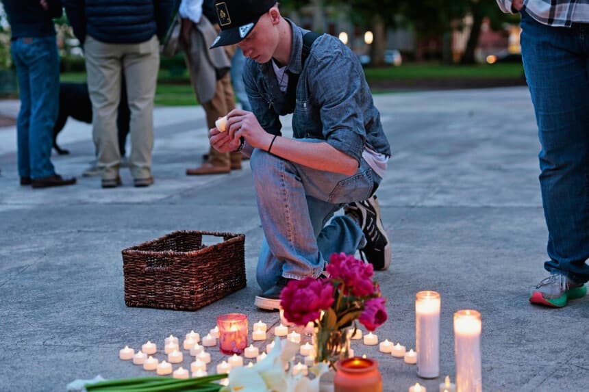 Kaeden Beck, de 16 años, coloca velas durante una oración vespertina y una vigilia en apoyo a las víctimas y sus familias afectadas por la implosión de un tanque de Nippon Dynawave Packaging Co., en el parque R.A. Long de Longview, Washington, el 26 de mayo de 2026. (Karen Ducey/The Seattle Times vía AP).