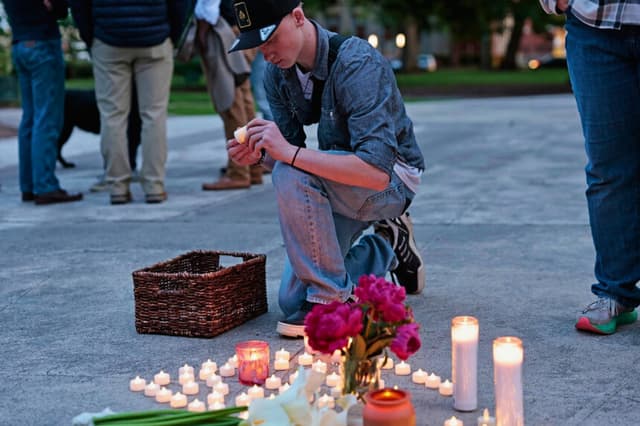 Kaeden Beck, de 16 años, coloca velas durante una oración vespertina y una vigilia en apoyo a las víctimas y sus familias afectadas por la implosión de un tanque de Nippon Dynawave Packaging Co., en el parque R.A. Long de Longview, Washington, el 26 de mayo de 2026. (Karen Ducey/The Seattle Times vía AP).