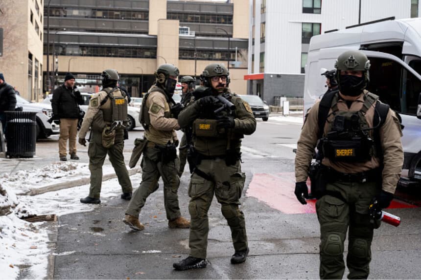 Agentes del sheriff del condado de Hennepin llegan al centro de Minneapolis para rescatar a un hombre atacado por manifestantes anti-ICE cerca del ayuntamiento, el 17 de enero de 2026 en Minnesota. (ROBERTO SCHMIDT / AFP vía Getty Images).