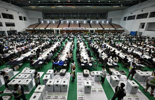 Funcionarios electorales clasifican las boletas en un centro de recuento para las elecciones locales en Seúl, Corea del Sur, el 3 de junio de 2026. (Pedro Pardo/AFP vía Getty Images)