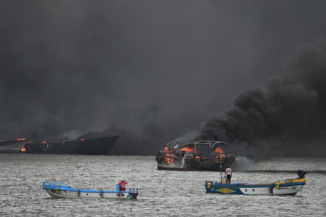 Varias embarcaciones incendiándose el sábado 6 de junio en el puerto de Manta (Ecuador). Al menos ocho embarcaciones pesqueras quedaron destruidas por incendios, sin que se conozcan aún las causas que provocaron el suceso. (EFE/ Ariel Ochoa)