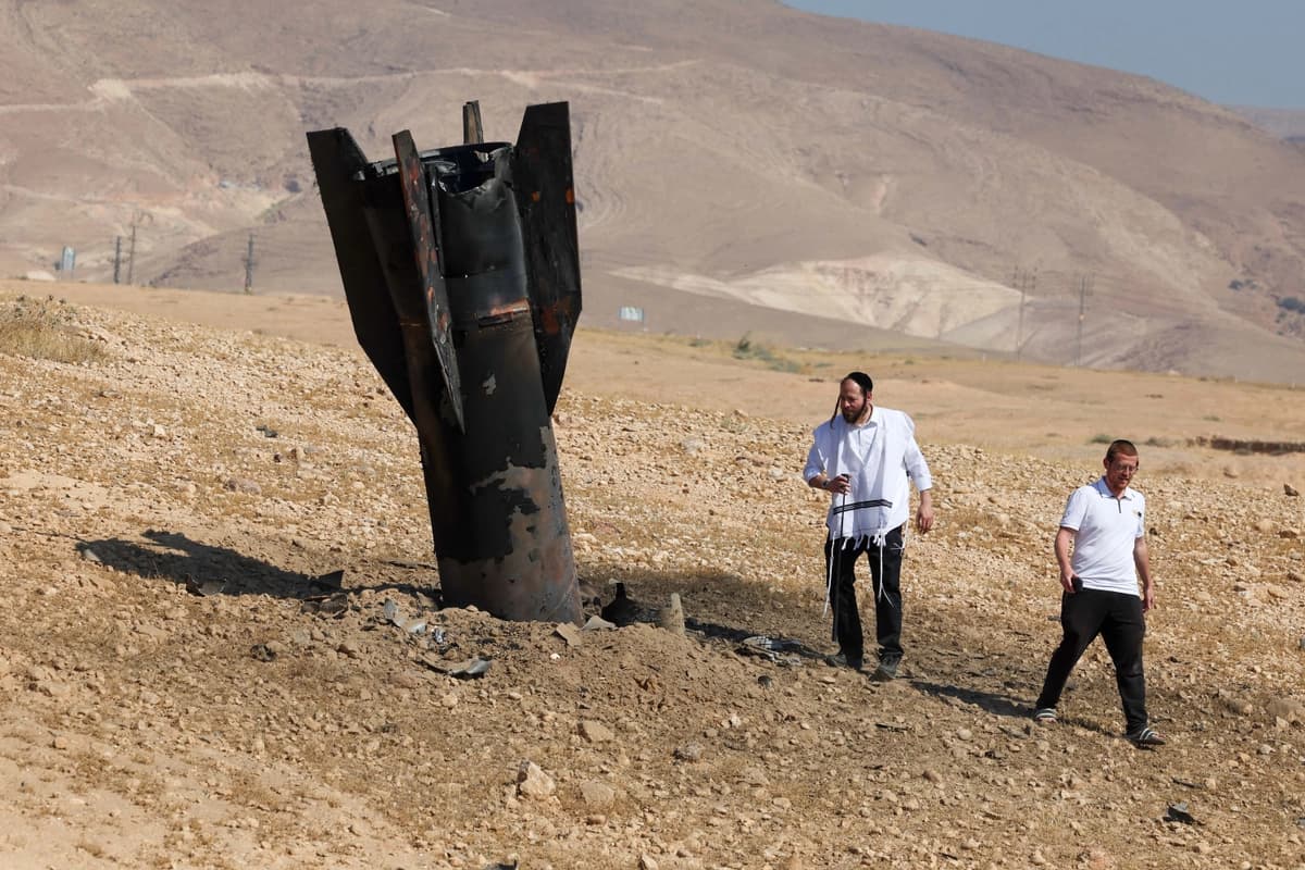 Dos hombres examinan un cohete caído y semienterrado en el suelo, tras los ataques de Irán y de los rebeldes hutíes respaldados por Irán en las afueras de Jericó, Israel, el 8 de junio de 2026. (Ahmad GHARABLI / AFP vía Getty Images)