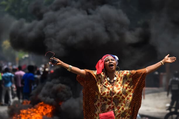 Una manifestante levanta los brazos y corea consignas durante una protesta contra el gobierno en el poder en Puerto Príncipe el 9 de junio de 2019. (CHANDAN KHANNA/AFP vía Getty Images)