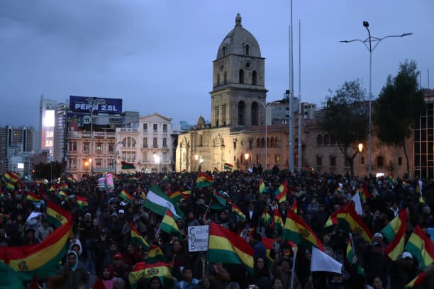 Personas sostienen banderas durante un cabildo donde exigen al gobierno declarar estado de excepción este martes, en el atrio de la basílica de San Francisco en La Paz, Bolivia. (EFE/ Luis Gandarillas)