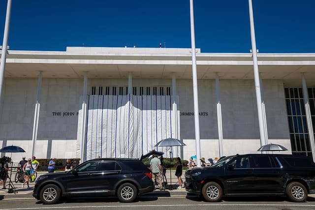 La gente y los medios de comunicación se concentran en el exterior mientras se cuelgan lonas en los andamios del Centro Kennedy el 13 de junio de 2026 en Washington, D.C. En la madrugada del viernes, unos trabajadores retiraron el nombre del presidente Donald Trump del Centro Kennedy. (Foto de Tasos Katopodis/Getty Images)